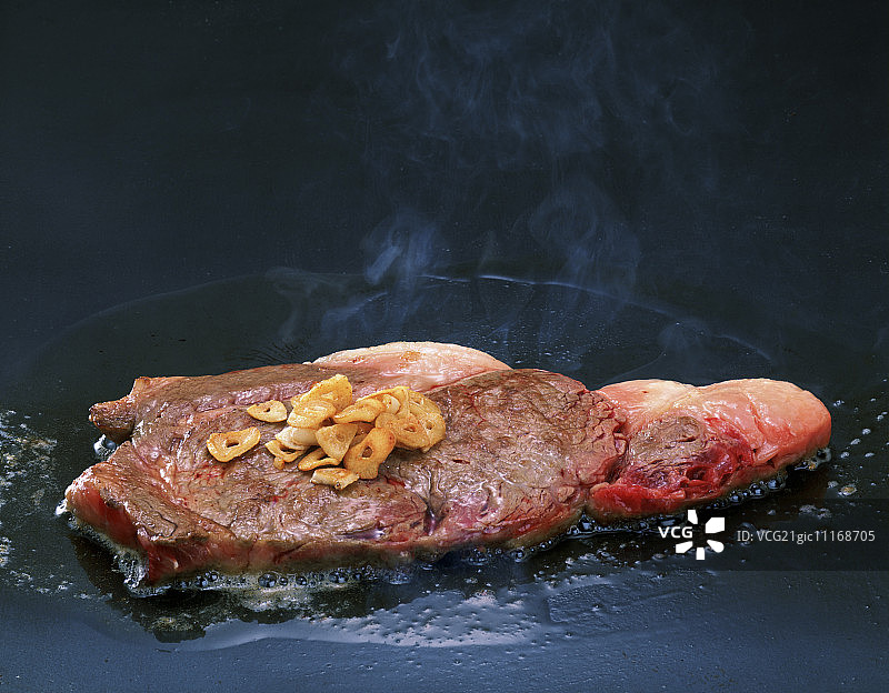 烤架上配大蒜的西冷牛排图片素材