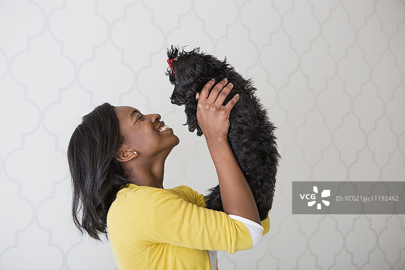 在白色背景前使用睫毛夹的迷人少女图片素材