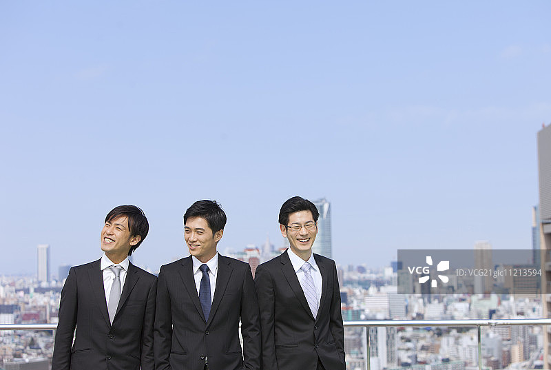 蓝天下站立的微笑商人图片素材