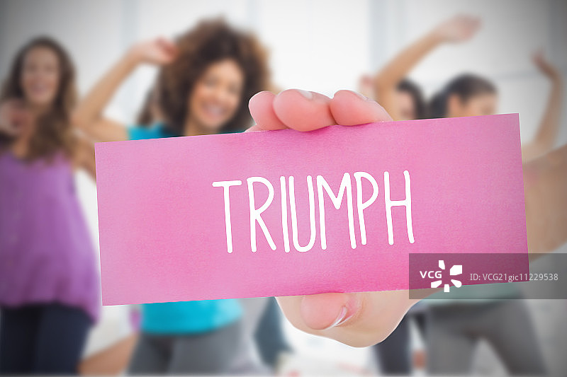 女士在健身房的尊巴课程中举着写着“胜利”的粉红色卡片图片素材