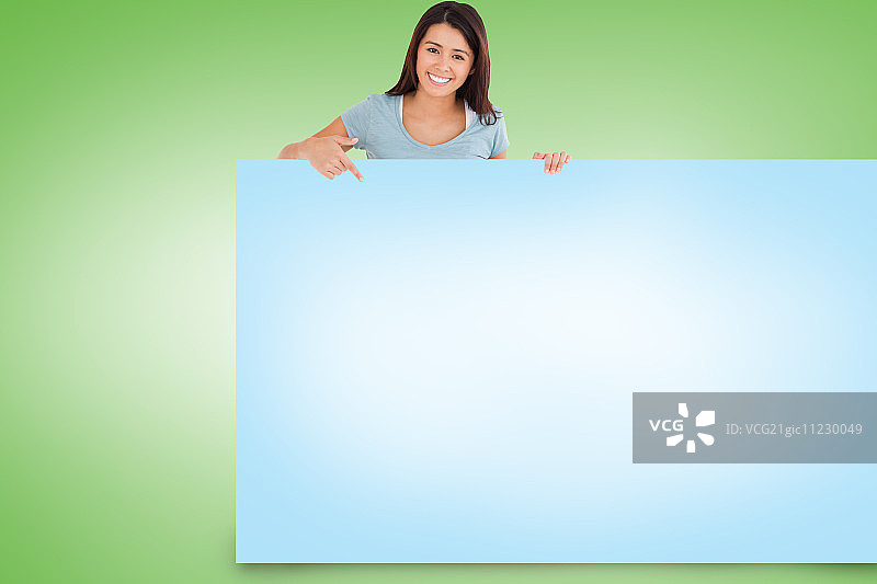 手持蓝色卡片的漂亮棕发女子合成图像图片素材