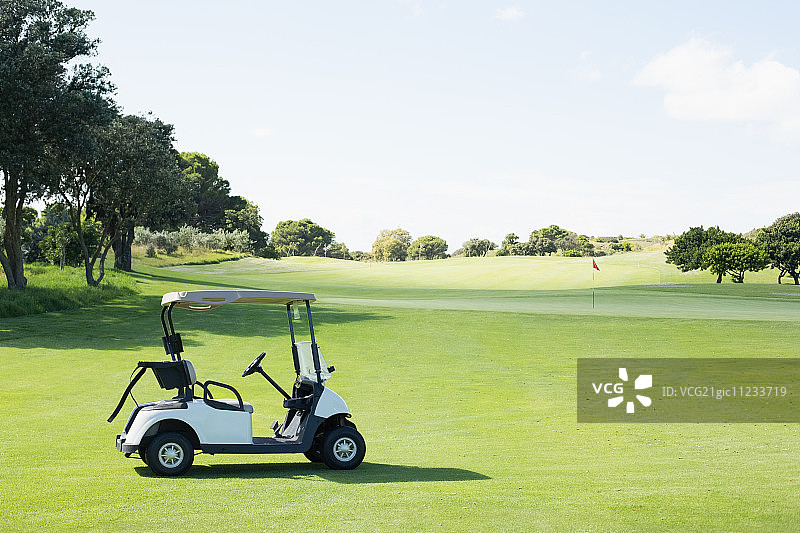 阳光明媚的高尔夫球场上的高尔夫球车图片素材