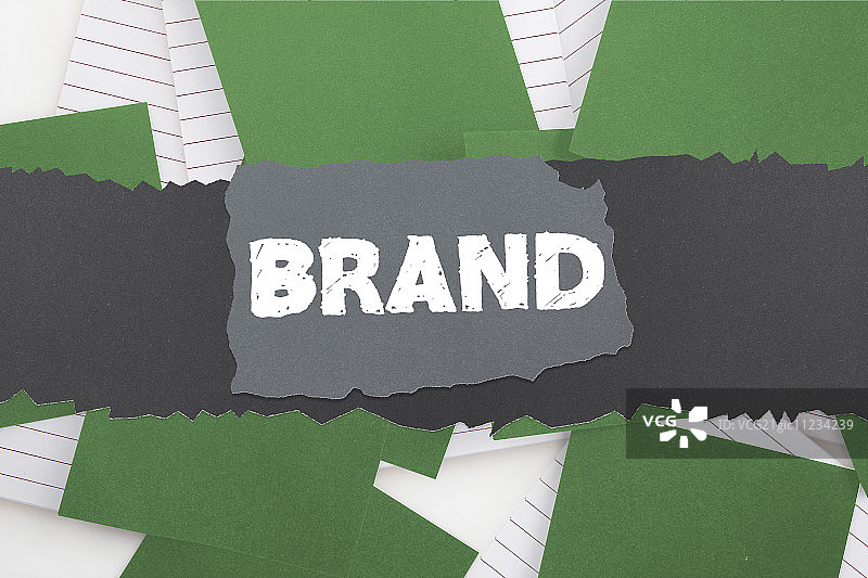 便签上散落的绿色纸张与“品牌”字样图片素材