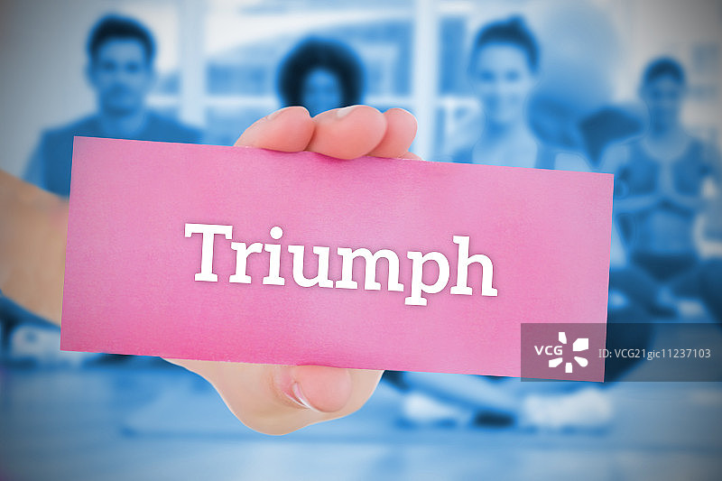 拿着粉色卡片，上面写着在健身房瑜伽课上取得胜利的女人图片素材