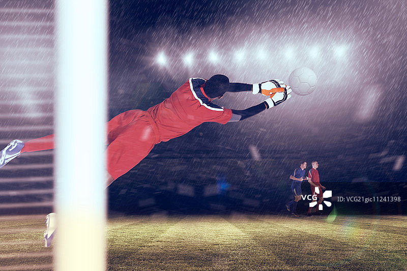 红色守门员在聚光灯下扑救图片素材