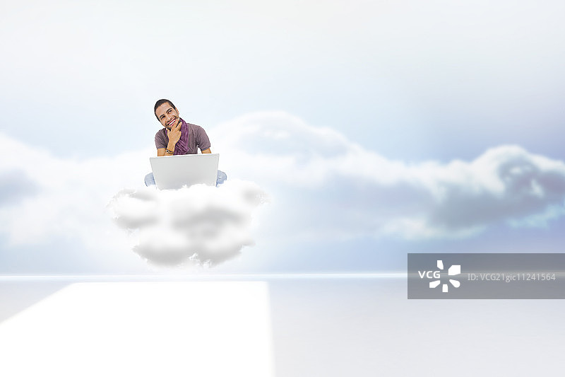 在房间里坐在云端使用笔记本电脑微笑的男子图片素材