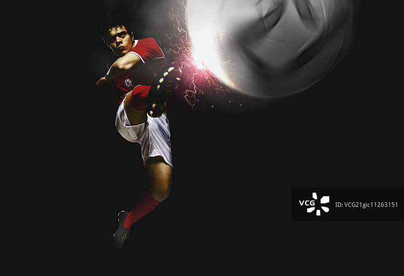 半空中踢球的足球运动员图片素材