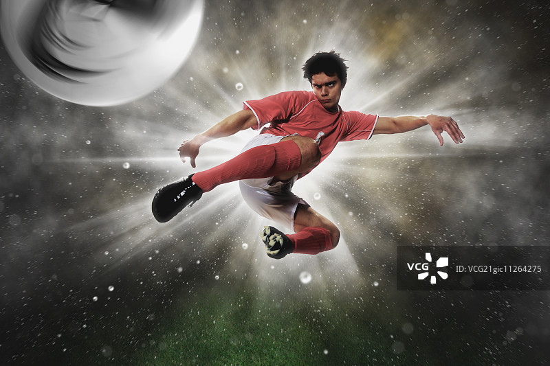 半空中踢球的足球运动员图片素材