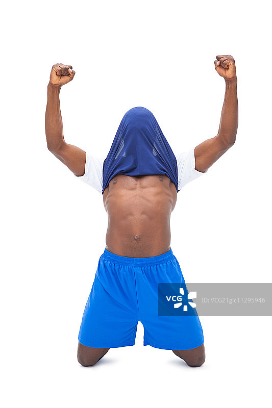 蓝色球衣的足球运动员在白色背景上庆祝胜利图片素材