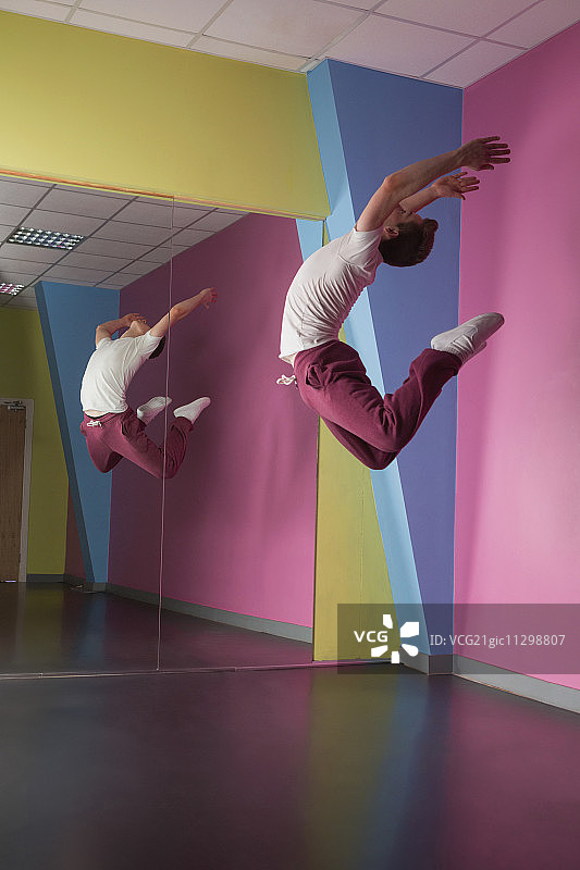 在舞蹈工作室的镜子前，空中炫酷的霹雳舞者图片素材