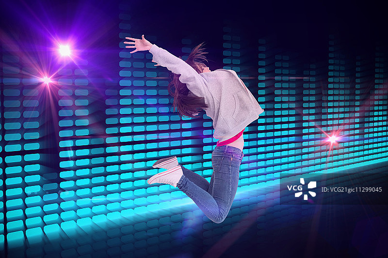 快乐的年轻女子在数码生成的迪斯科灯光设计中跳跃图片素材