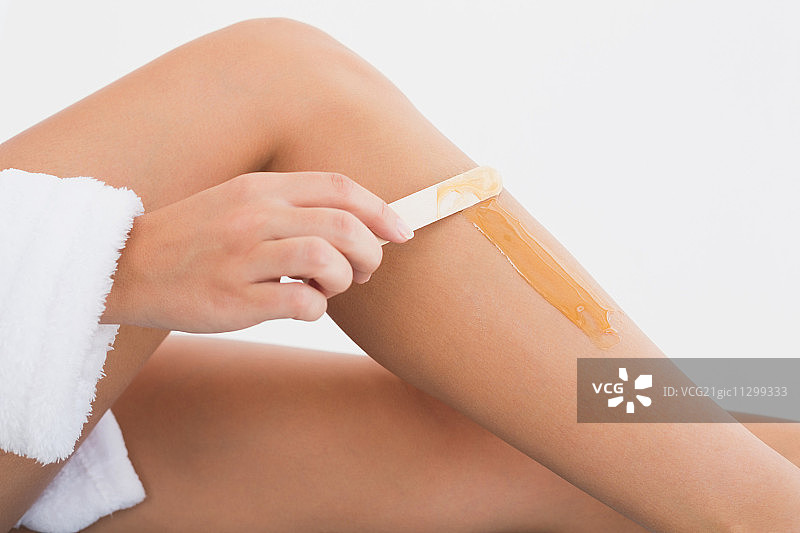 水疗中心女人腿部热蜡脱毛侧视图特写图片素材