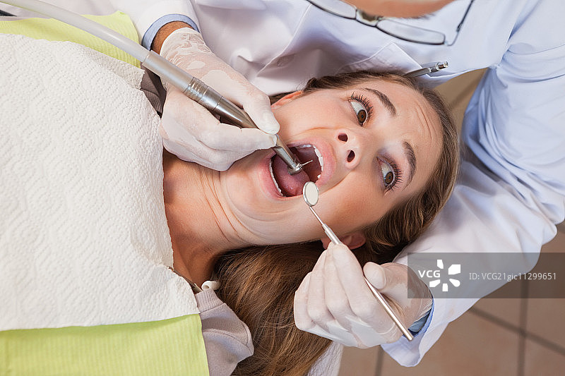 牙医在牙科诊所为恐惧的病人拔牙图片素材
