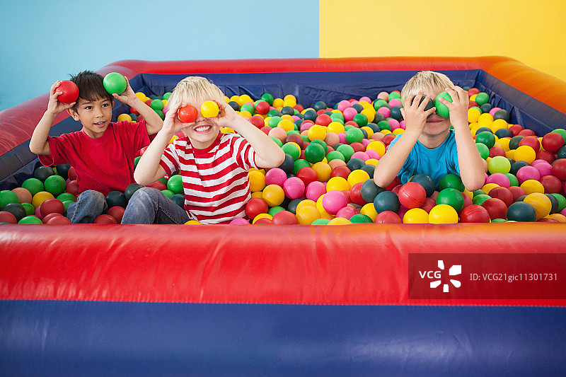 快乐的孩子们在聚会上的球池里玩耍图片素材