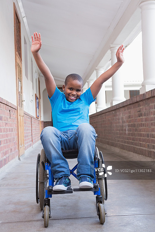 小学走廊里对着镜头微笑的可爱残疾学生图片素材