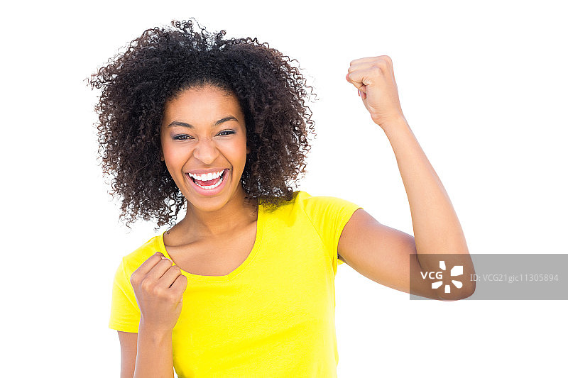 穿着黄色T恤和牛仔热裤，对着镜头欢呼雀跃的漂亮女人图片素材