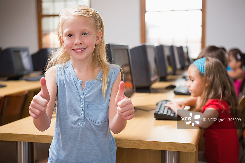 小学电脑课上对着镜头微笑的可爱小学生图片素材