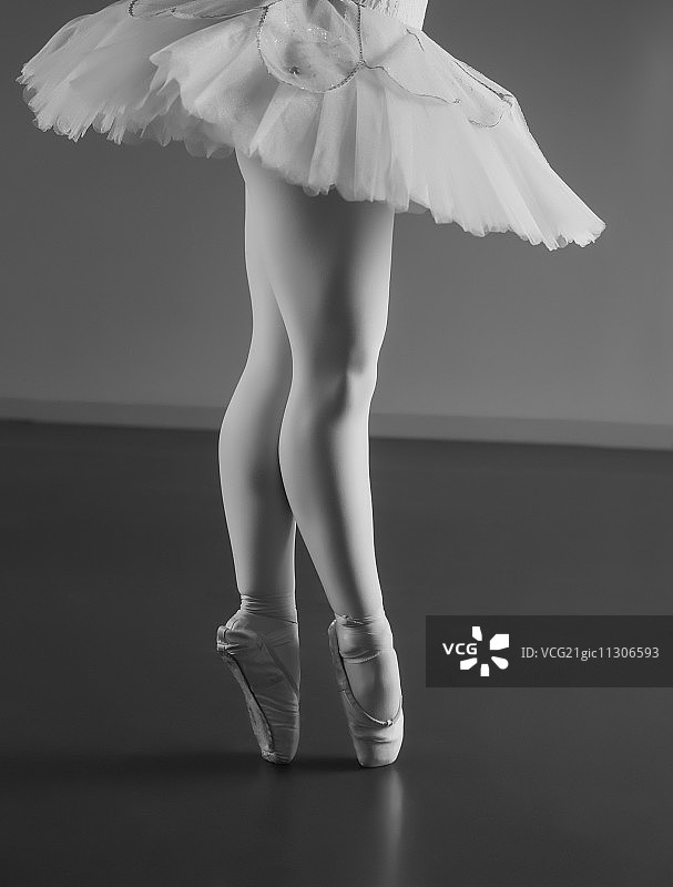 芭蕾舞工作室中优雅的足尖站立芭蕾舞演员图片素材
