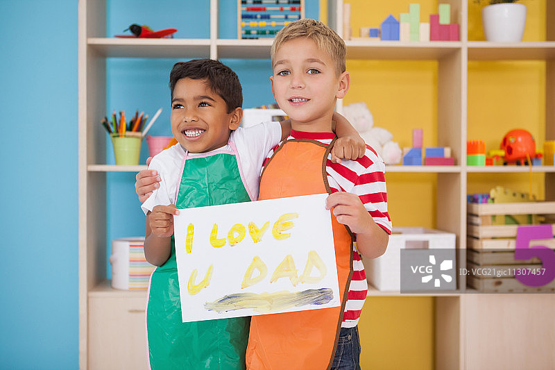 在幼儿园展示父亲节画作的可爱小男孩们图片素材