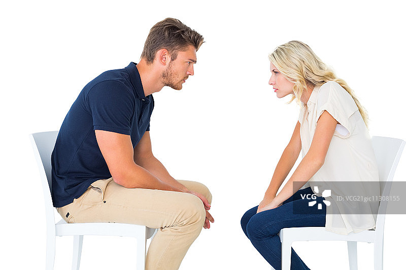 年轻情侣坐在椅子上争吵，白色背景图片素材