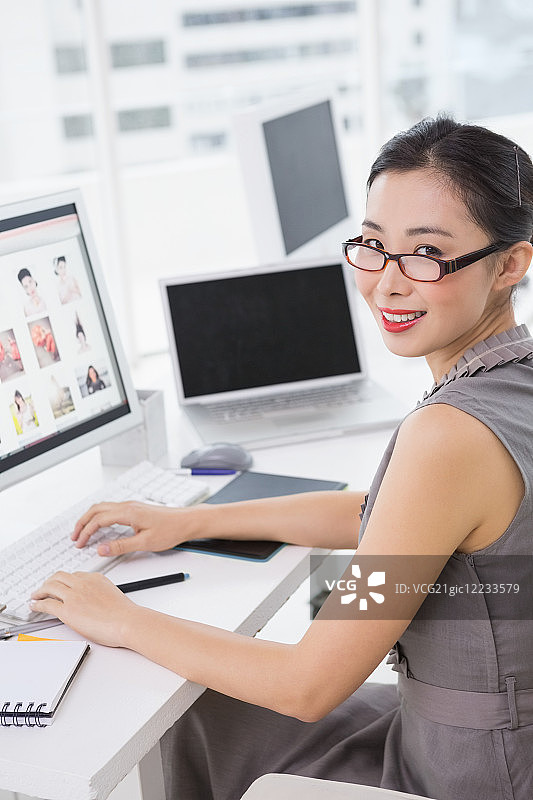 创意办公室内，照片编辑在办公桌前工作图片素材