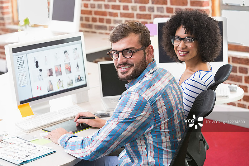 办公室里使用数字化仪的微笑的图片编辑图片素材