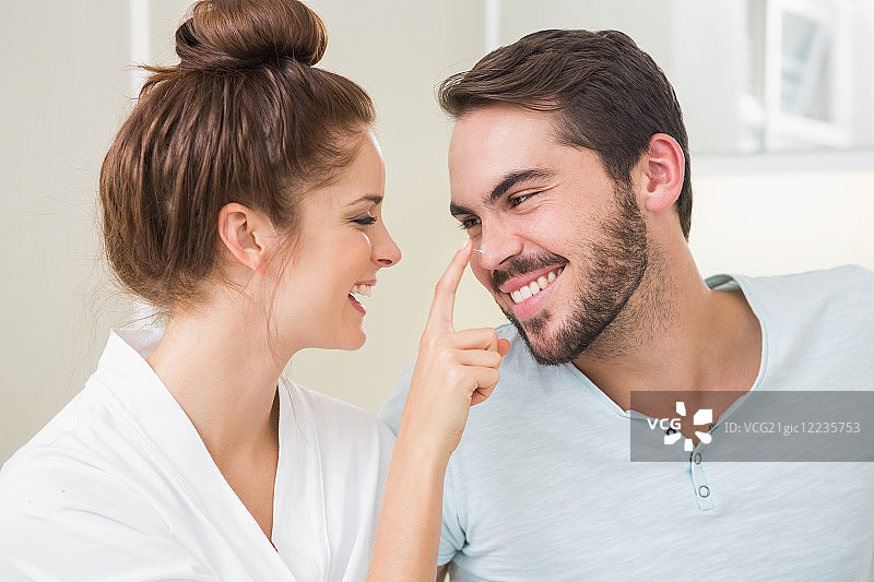 年轻女人在家中浴室轻触男友的鼻子图片素材
