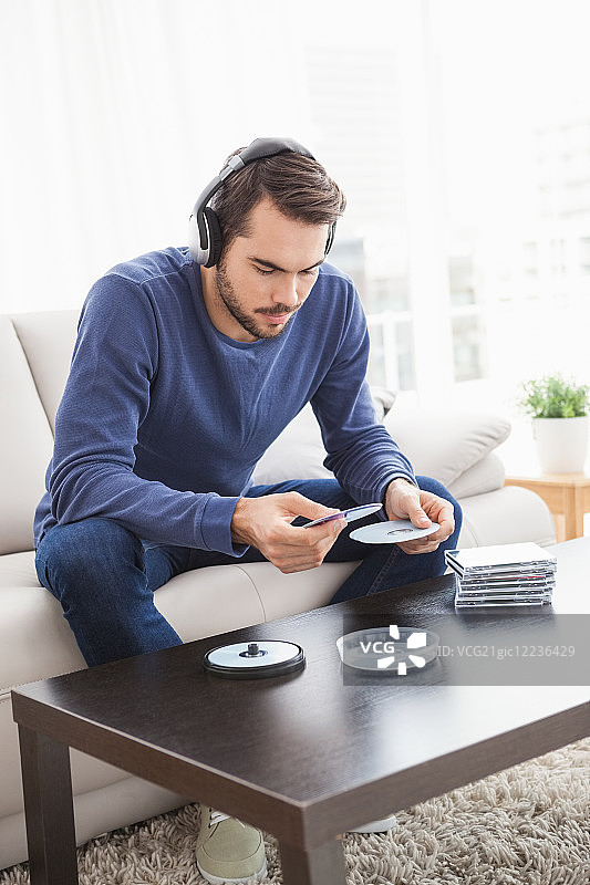 在家中客厅听CD的年轻男人图片素材