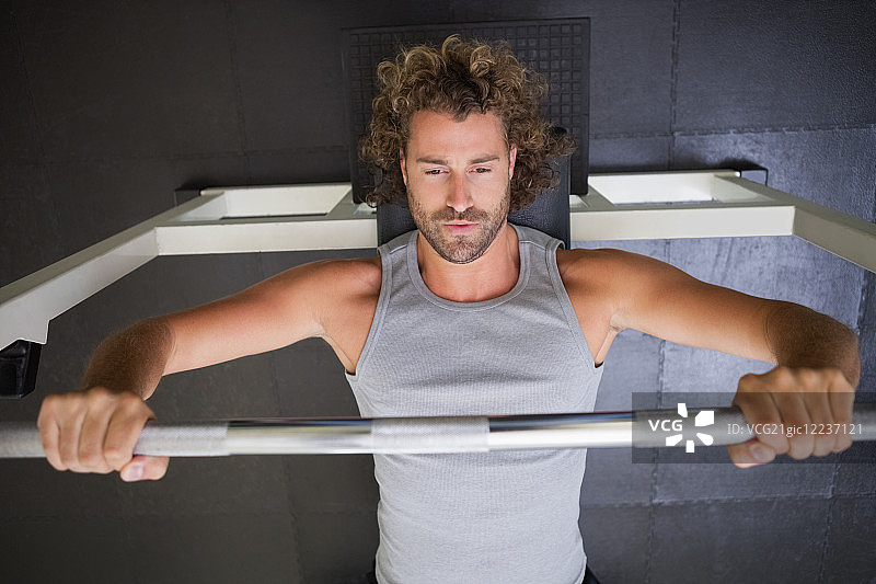 健身房里举杠铃的年轻健壮男子俯视图图片素材