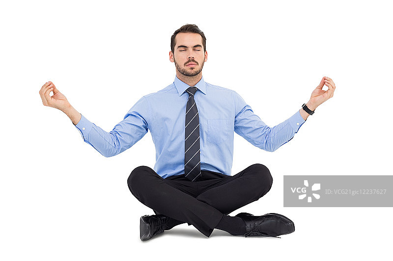 平静的男人在白色背景上呈莲花坐姿图片素材