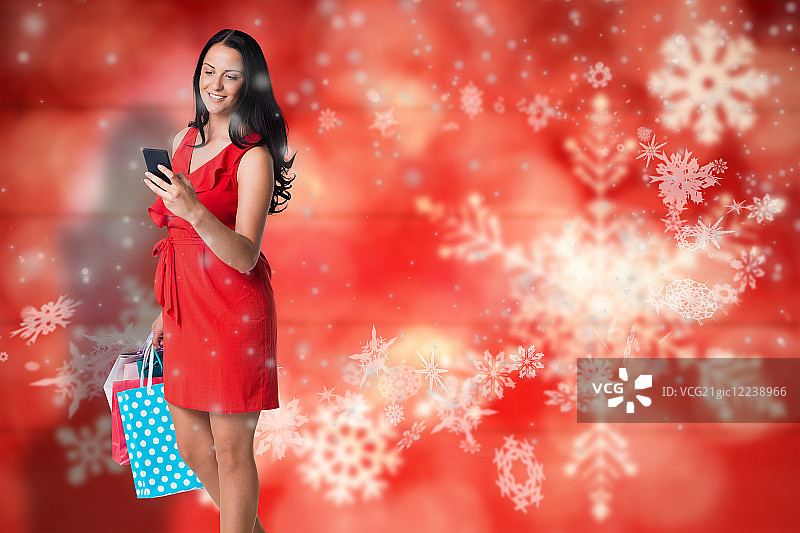 手提购物袋，站在木板模糊雪花背景前的女人图片素材