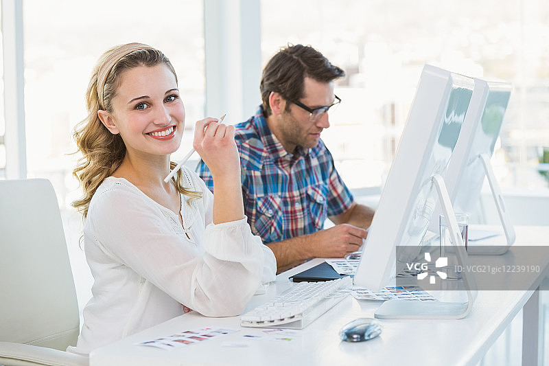 在办公室对着镜头微笑的修图师图片素材