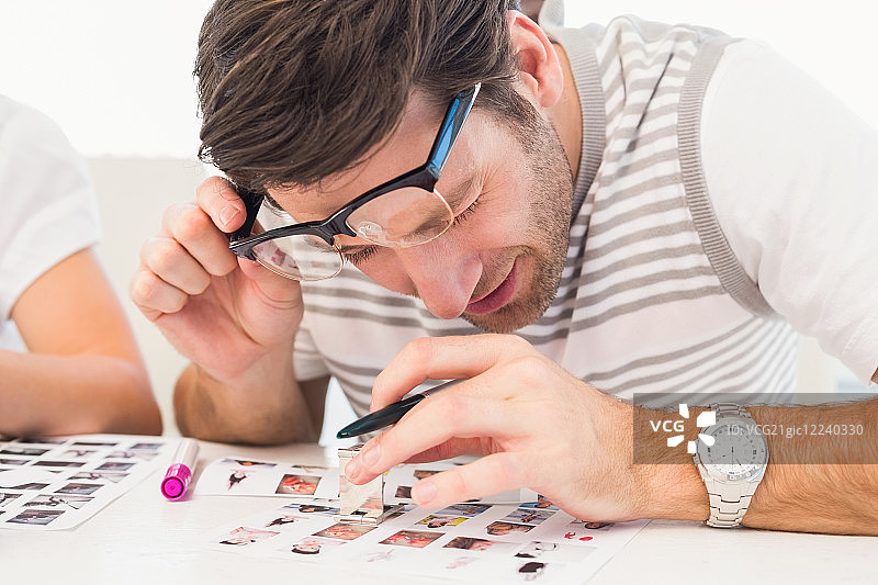 照片编辑师在办公室使用放大镜图片素材