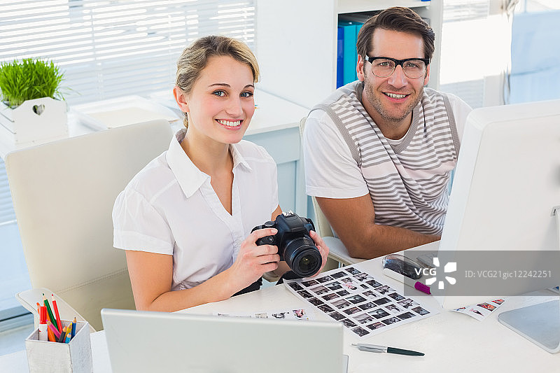 办公室里拿着相机的休闲摄影师图片素材