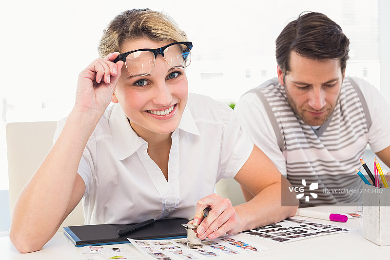 编辑在办公室使用放大镜看镜头图片素材