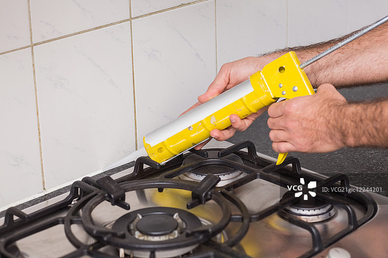 水管工在厨房瓷砖之间填充图片素材