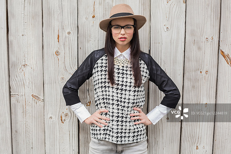 在漂白木板前为相机摆姿势的时尚人士图片素材