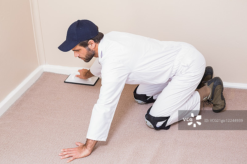 修理工在新房铺设地毯图片素材