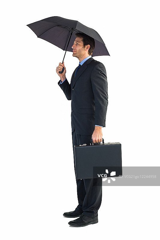 在白色背景下手拿公文包的雨伞下的商人图片素材