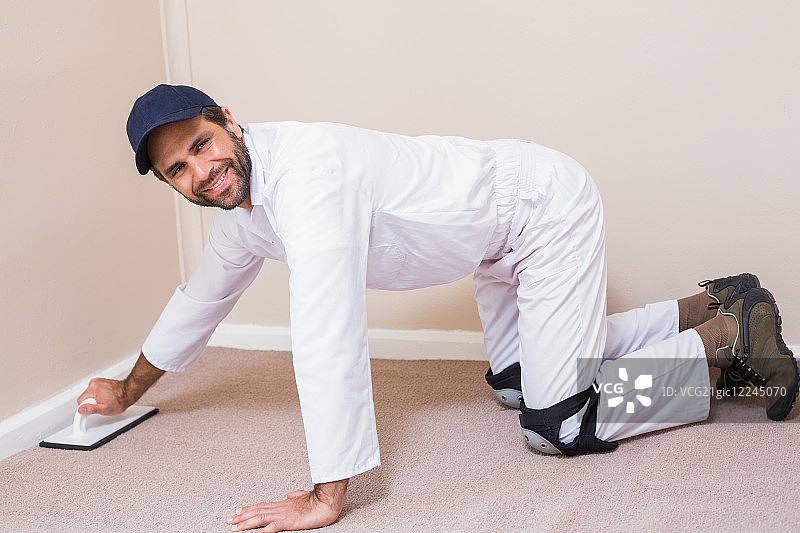 修理工在新房铺设地毯图片素材