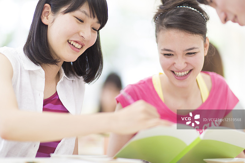 微笑阅读课本的女大学生图片素材