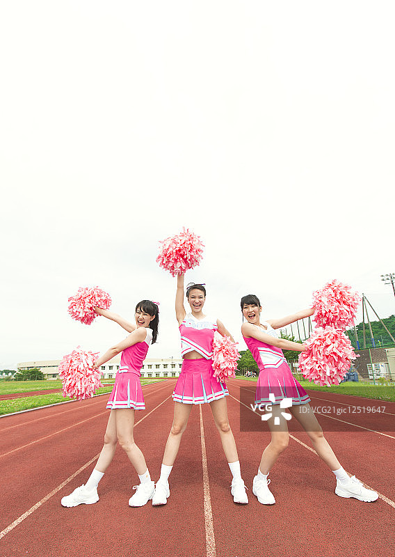 三个啦啦队员用绒球欢呼图片素材