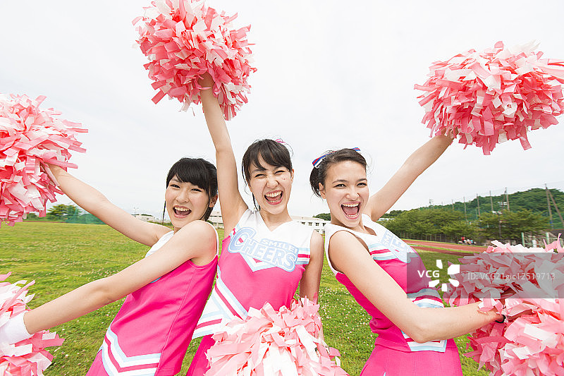 三个啦啦队员用绒球欢呼图片素材