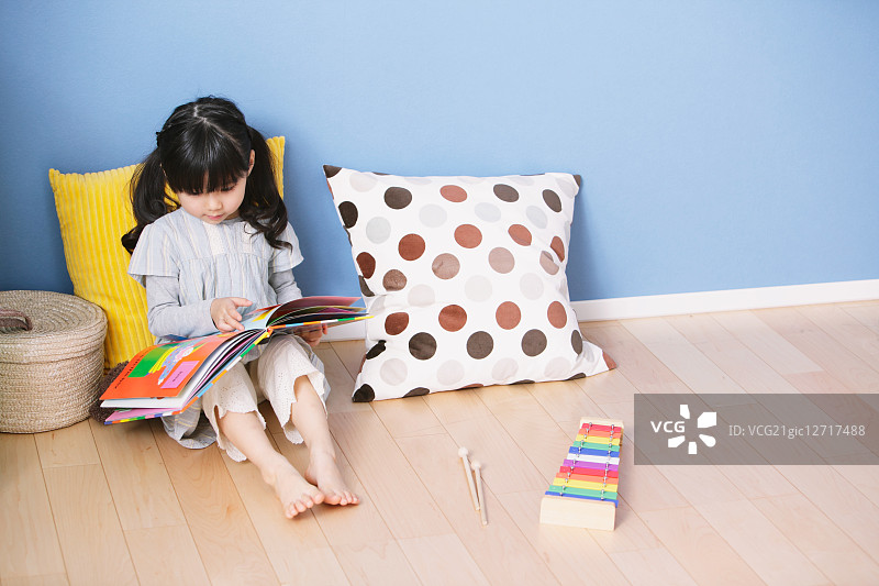 小学生在儿童房的地板上阅读图画书图片素材