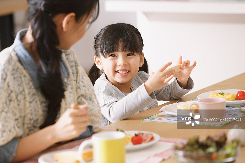 早餐时，年轻母女互相微笑图片素材