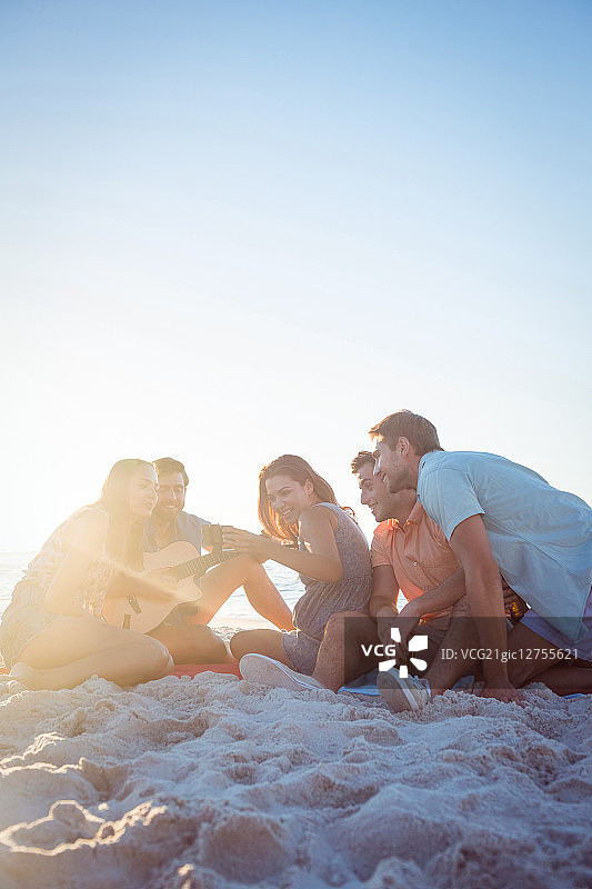 在海滩放松和弹吉他的快乐潮人图片素材