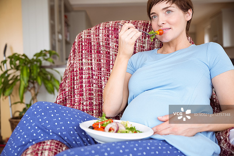 孕妇在客厅里吃沙拉图片素材