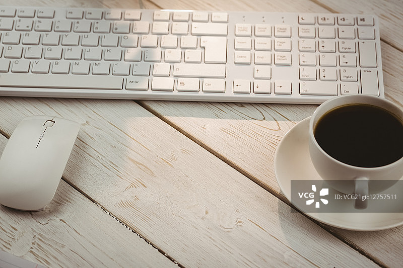 办公桌上的白色键盘和咖啡杯图片素材