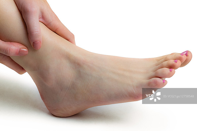 在白色背景下手踝受伤的女人图片素材