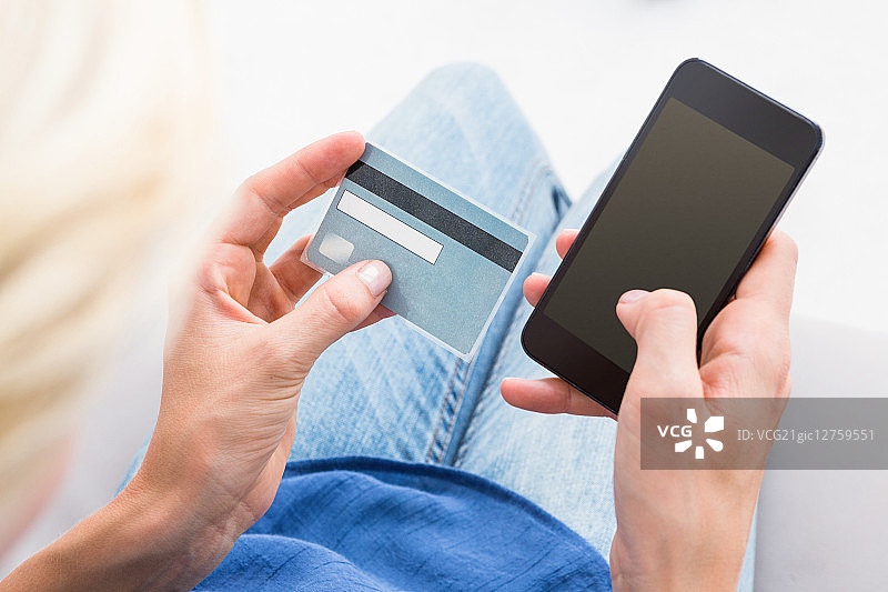 女人在白色背景上用手机做网上购物图片素材